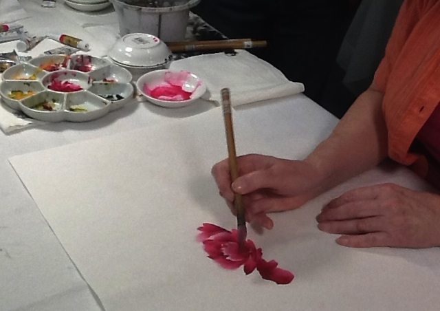 Artist paints outer ring of red petals