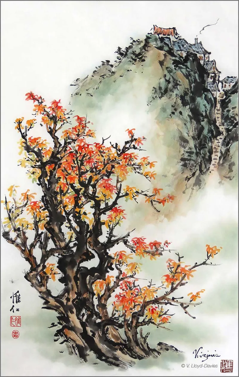 Orange fall tree with mountain village in the background