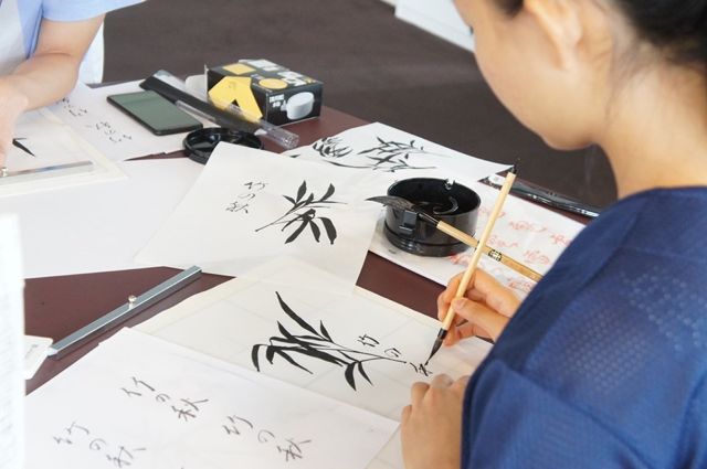 Picture student painting in black ink