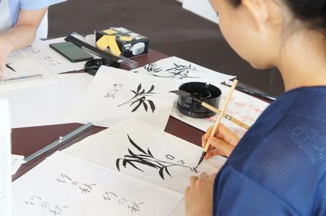 Picture student painting in black ink