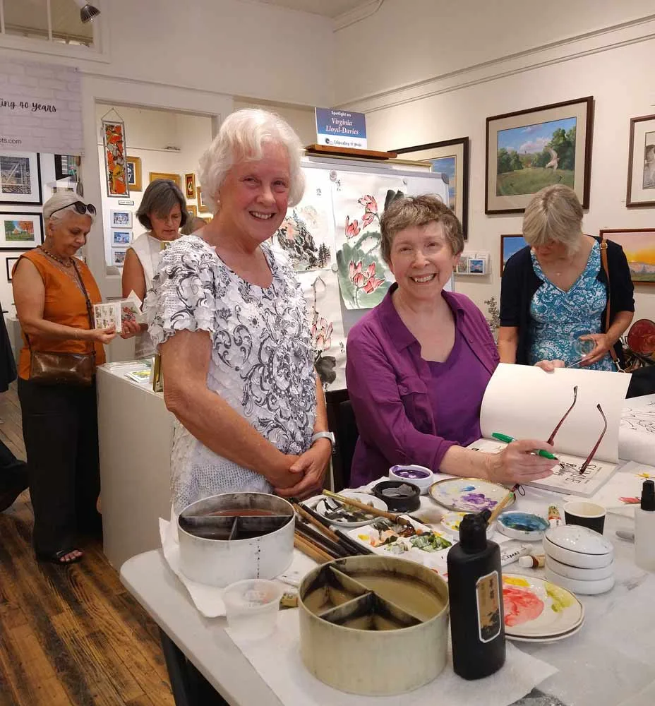 Virginia Lloyd-Davies with painting of grapes and birds at Potomac Falls Health & Rehab Center, Sterling VA