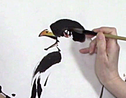 Hand and brush filling in color in bird's eye Picture