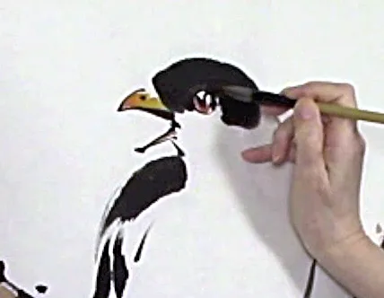 Hand and brush filling in color in bird's eye Picture